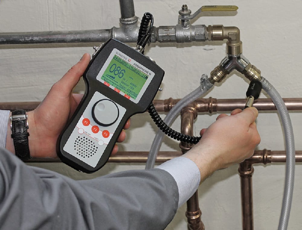 Plumber testing pipes with electronic leak detection equipment in Greenfield