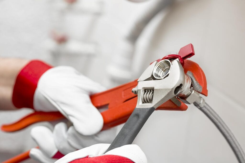 Plumber holding pipe wrenches for an emergency repair in Greenfield
