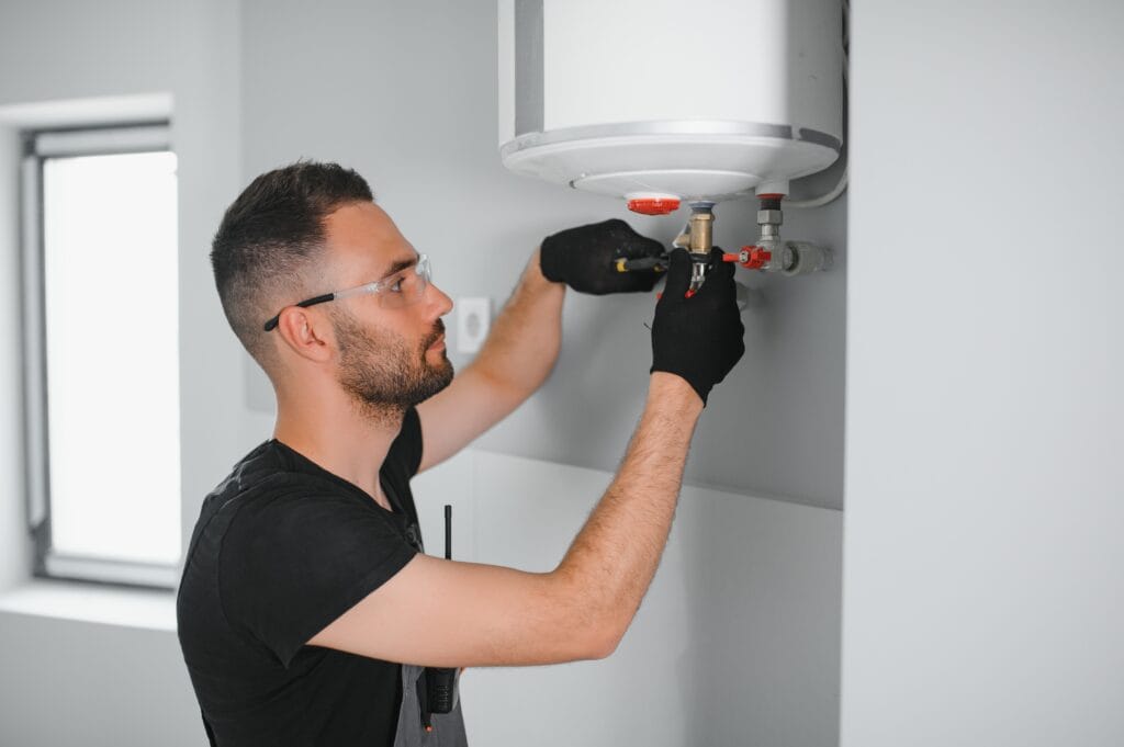Technician performing water heater maintenance in Greenfield