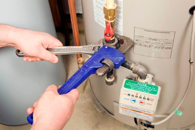 Plumber repairing a water heater valve in Greenfield
